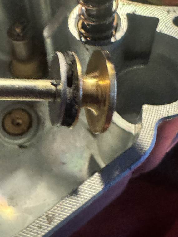IMG_3240 Macro of brass accelerating pump piston head showing shredded half-missing black rubber seal ring inside lower groove